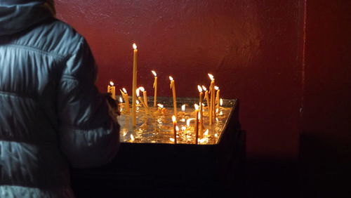 Close-up of illuminated candles against dark background