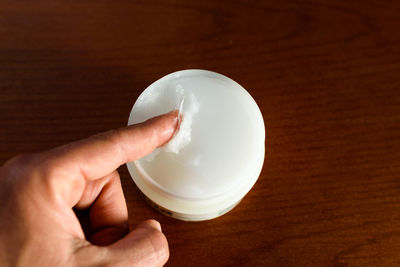 Cropped hand holding crystal ball on table