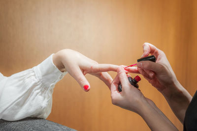 Beautician applying nail polish to woman in parlor