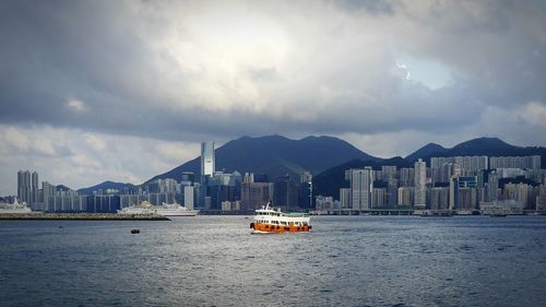 Boats in river with city in background