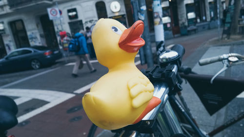 Close-up of rubber duck on bicycle at city street