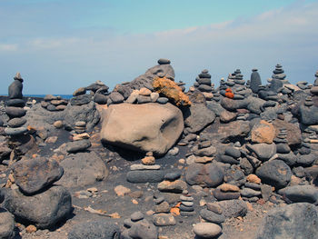 Close-up of pebbles on beach against sky