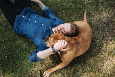 Young man lying down with his dog