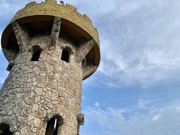 Low angle view of old ruin building against cloudy sky