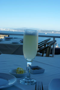 Close-up of drink on table by sea against sky