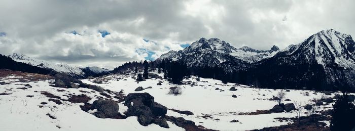 Scenic view of snow covered mountains against cloudy sky