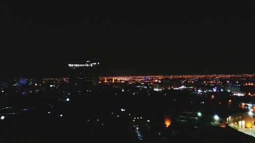 Illuminated cityscape against sky at night