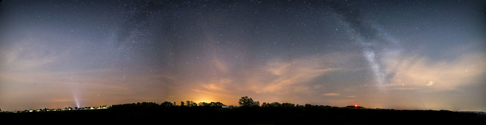 Silhouette trees against sky at night