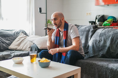 Portrait of senior man using mobile phone while sitting at home