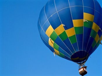 Low angle view of balloons against clear blue sky