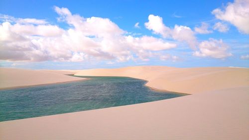 Scenic view of beach against cloudy sky