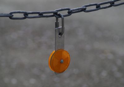 Close-up of chain hanging on metal fence