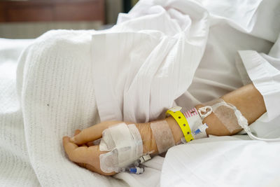 Midsection of patient wearing iv drip in hospital