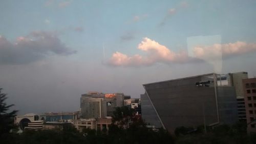 Buildings in city against cloudy sky