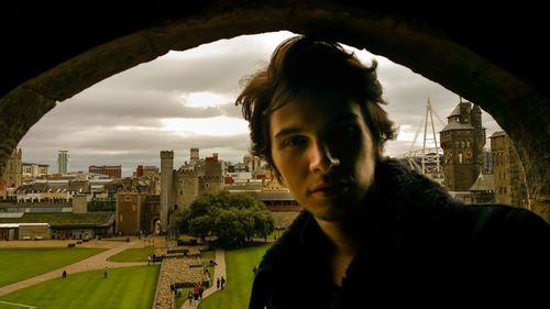 Close-up portrait of man with cityscape in background