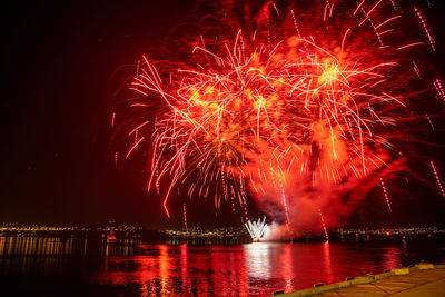 Firework display over river at night