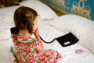 High angle view of girl on bed at home