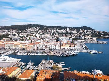 High angle view of townscape by sea against sky