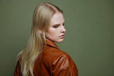 Portrait of young woman against gray background