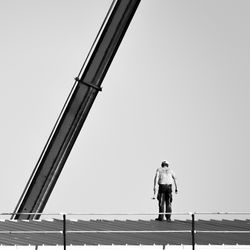 Rear view of man standing against clear sky