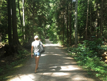 Rear view of man walking in forest