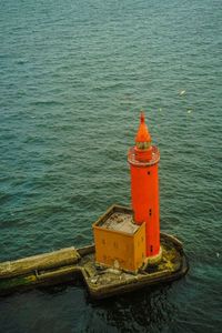 High angle view of red lighthouse by sea