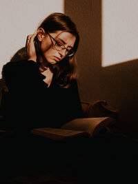 Young woman sitting with book
