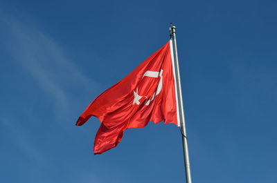 Low angle view of flag against blue sky