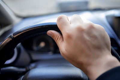 Midsection of human hand in car