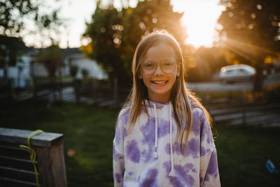 Portrait of happy girl wearing hoodie during sunset