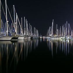 Boats in calm lake at night