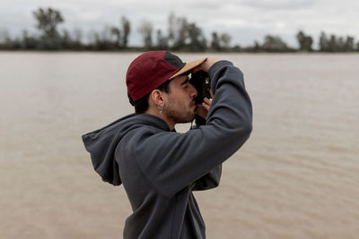 Side view of man standing by water