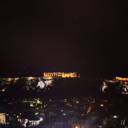 Illuminated city against sky at night