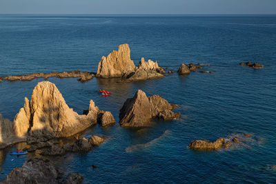 Rock formations in sea against sky