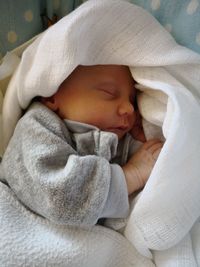 Close-up of baby sleeping in bed