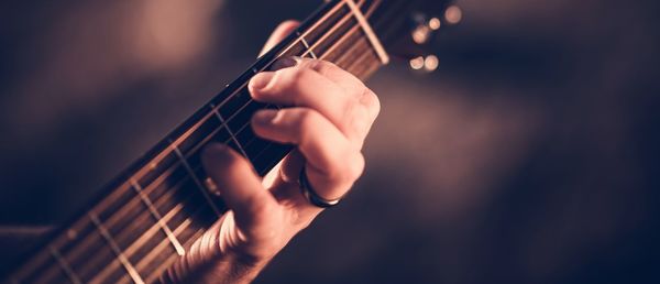 Close-up of hand playing guitar