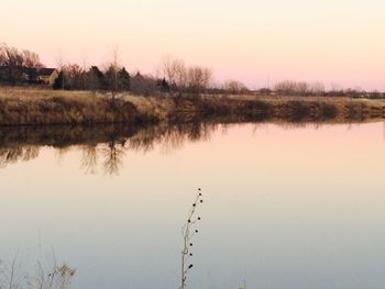 Scenic view of lake against clear sky at sunset