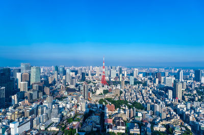 Aerial view of city buildings against blue sky