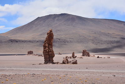 Scenic view of desert against cloudy sky