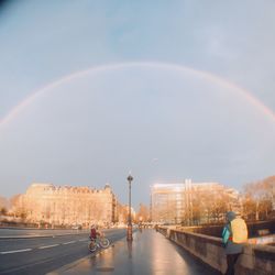 Scenic view of rainbow over city against sky