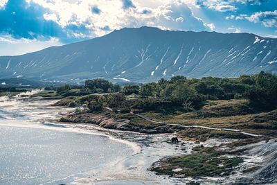 Scenic view of sea and mountains against sky