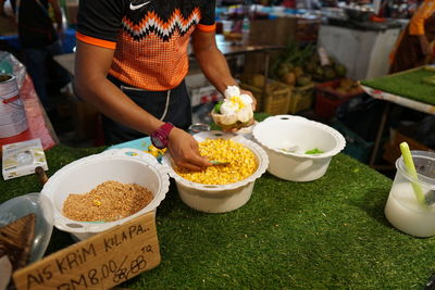 Midsection of woman standing at market stall