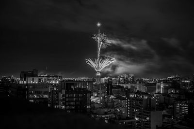 Illuminated cityscape against sky at night