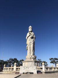 Low angle view of statue against blue sky