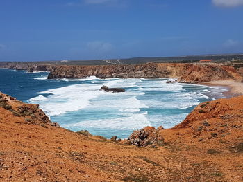 Scenic view of beach against blue sky