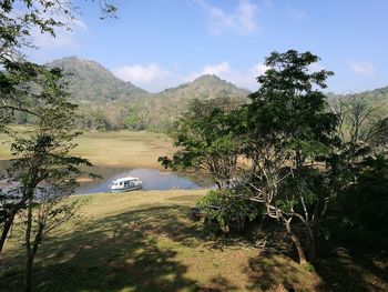 Scenic view of lake by trees against sky