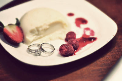 Close-up of wedding ring and dessert in plate