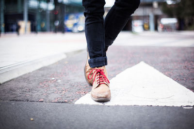 Low section of man walking on road