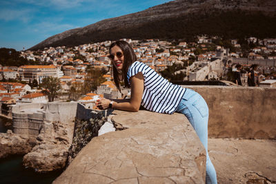 Rear view of woman sitting on rock