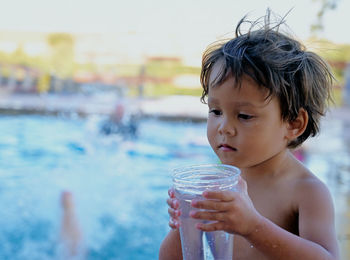 Portrait of shirtless boy drinking water
